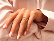 Gold beaded stackable rings on a hand, jewelry