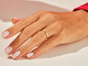 Gold band ring on a manicured hand, jewelry product shot