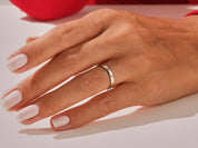 Elegant silver band ring on a manicured hand, jewelry photography