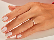 Rose gold band ring on a woman's finger, jewelry