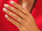 Gold wedding band on a hand with white nails, jewelry