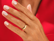 Gold wedding band on a hand with white nails, jewelry