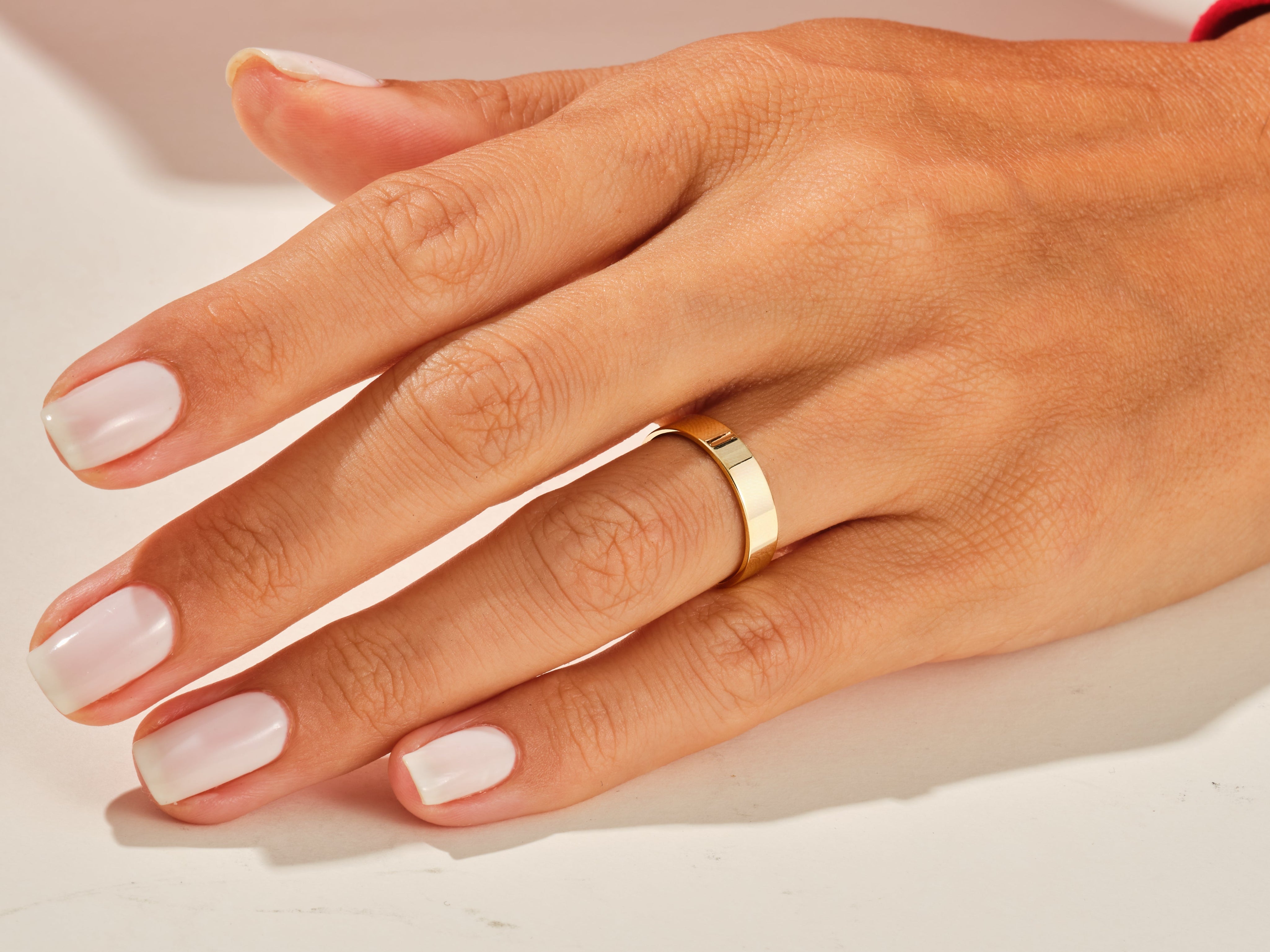 Gold band ring on a woman's finger, jewelry product