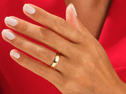 Gold wedding band on a hand, showcasing fine jewelry craftsmanship