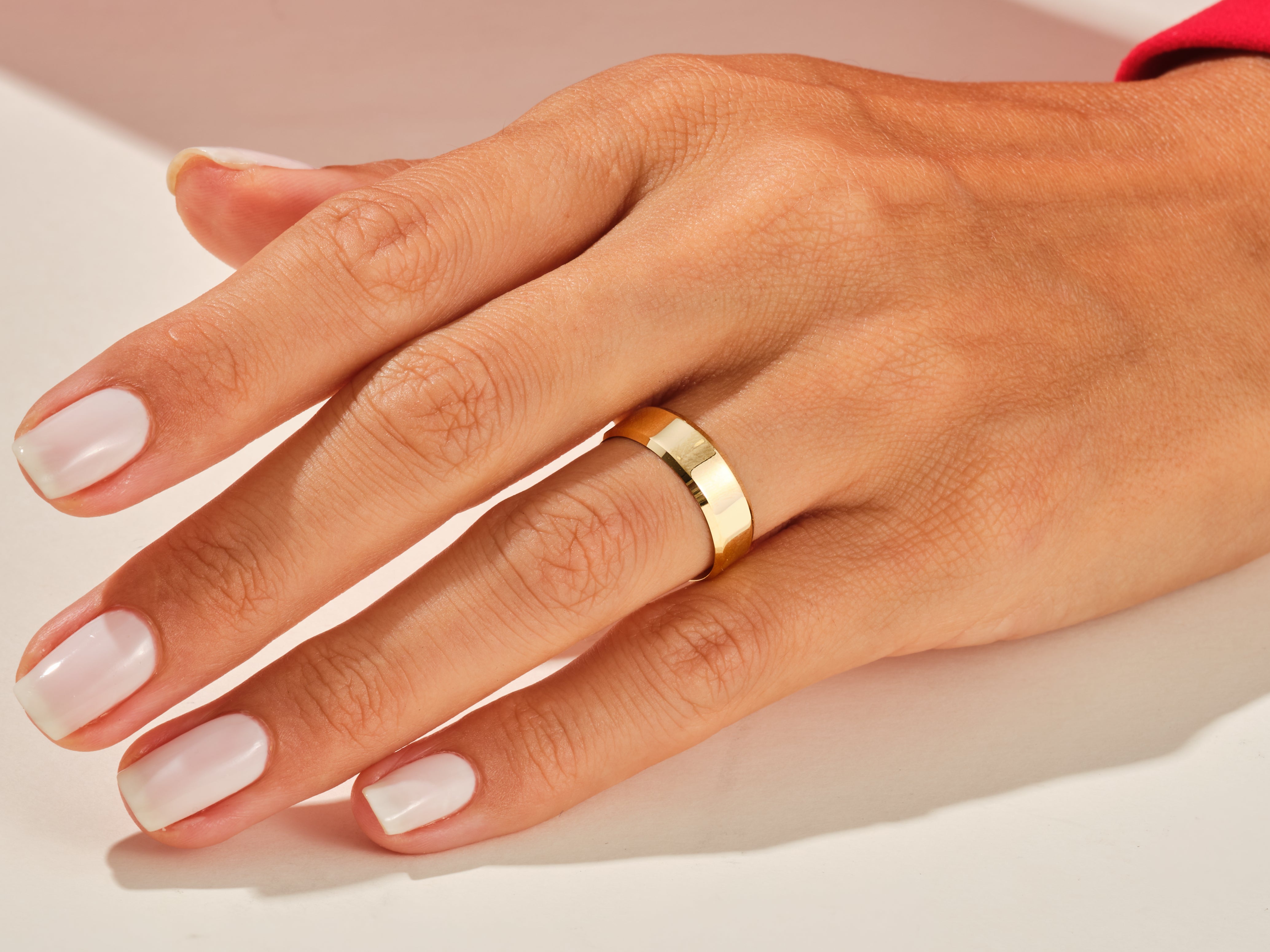Gold band ring on a woman's hand, jewelry photography