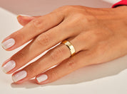 Gold band ring on a woman's hand, jewelry photography