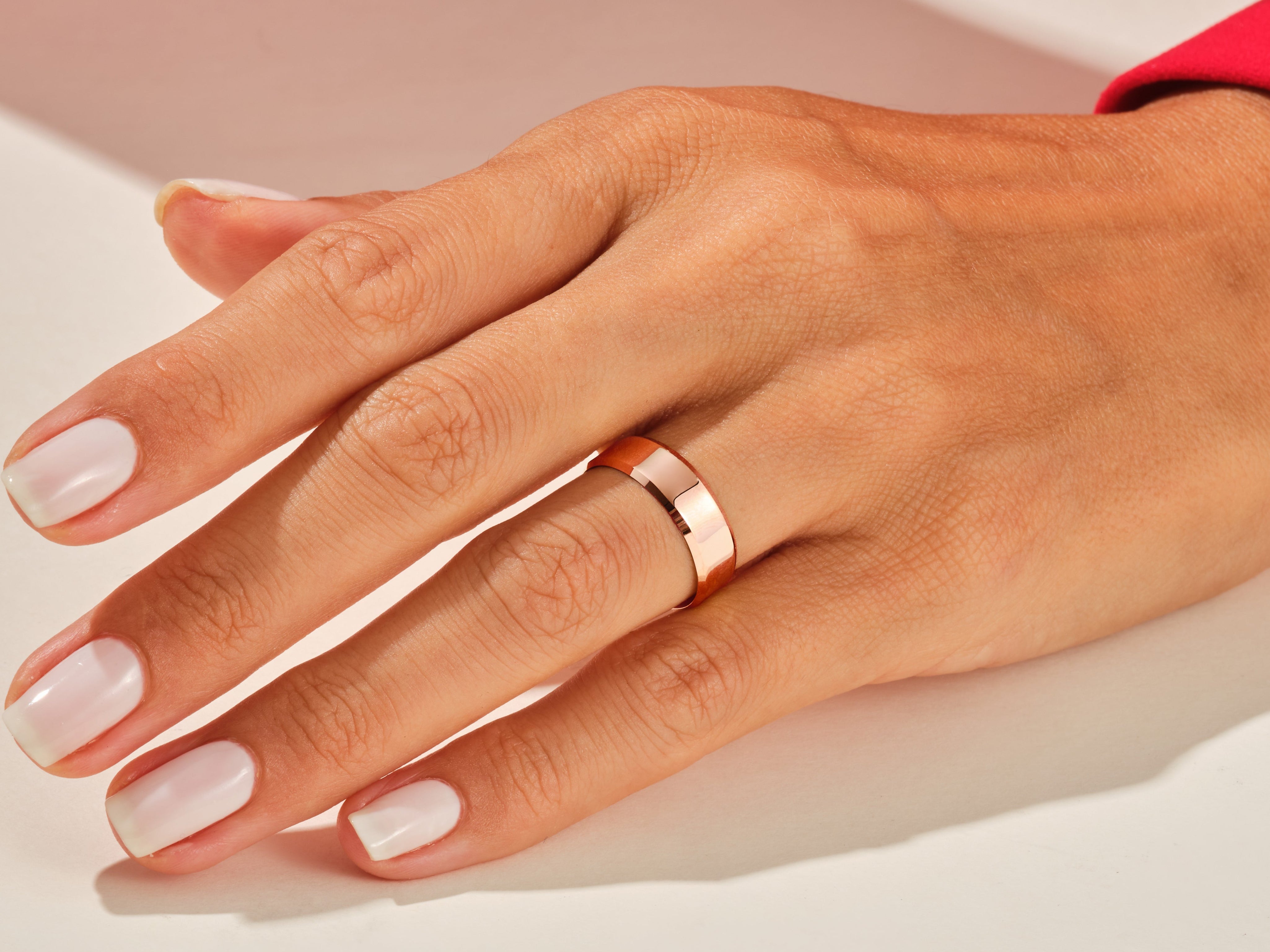 Rose gold band ring on a woman's hand, jewelry photography