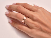 Rose gold band ring on a woman's finger, elegant jewelry