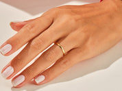 Gold band ring on a woman's finger, jewelry product photography
