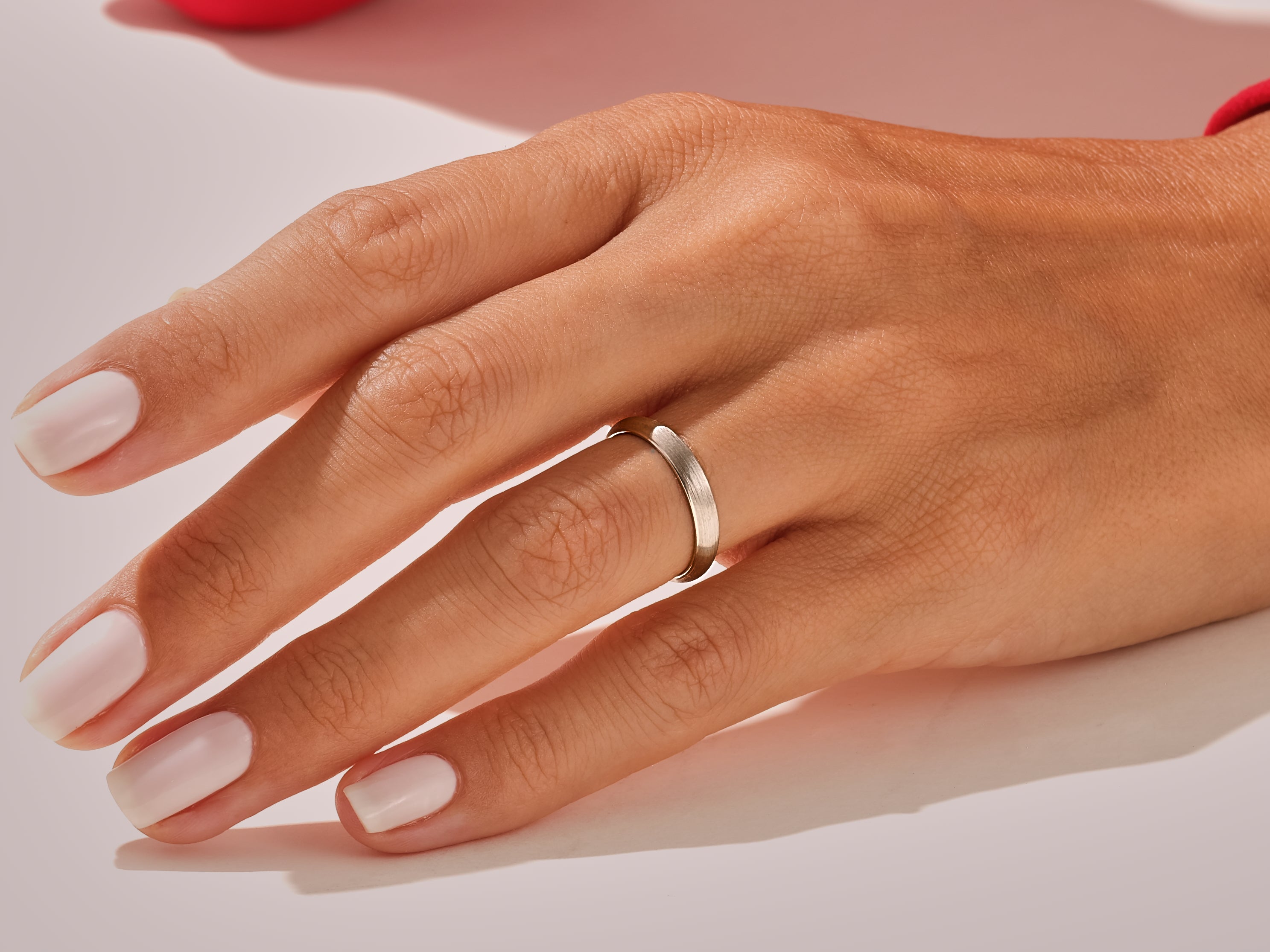 Elegant silver band ring on a manicured hand, jewelry photography