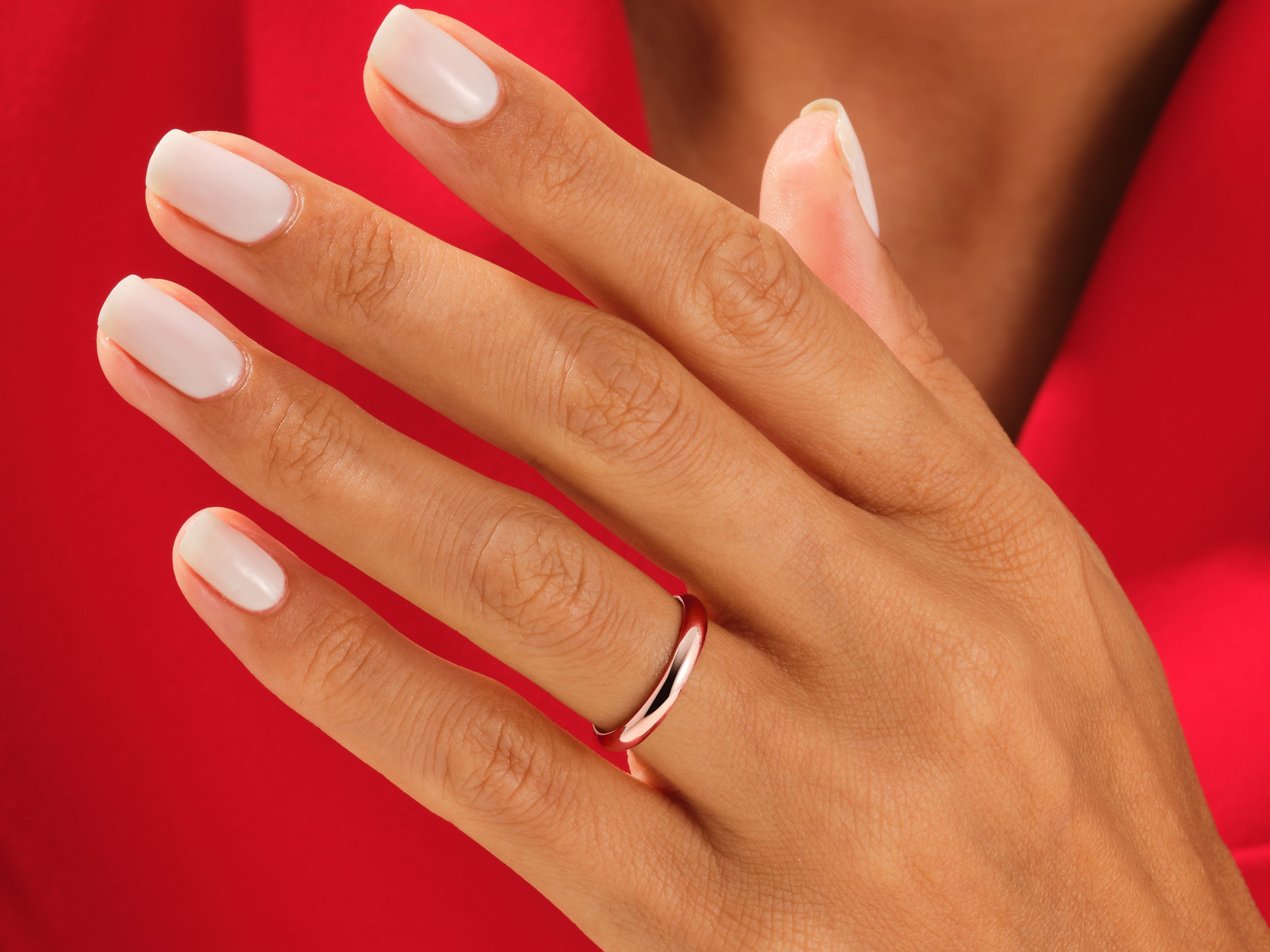 Rose gold ring on a hand with white nails, jewelry product