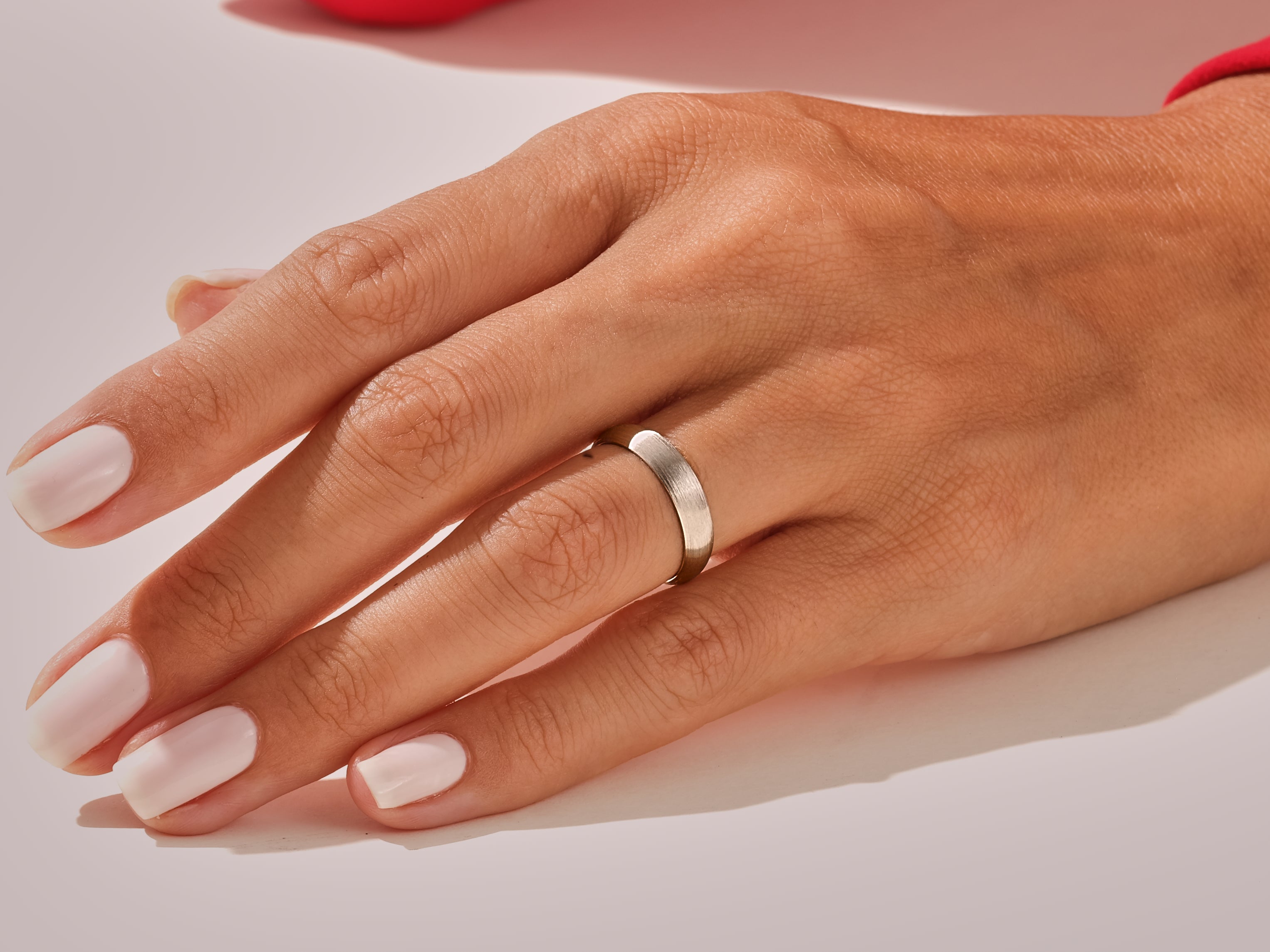 Close-up of a hand wearing a simple, elegant silver band ring