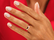 Rose gold ring on a hand with white nails, jewelry product shot