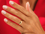 Gold wedding band on a hand with manicured nails, jewelry