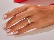 Silver band ring on a hand with manicured nails