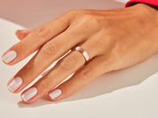 Rose gold band ring on a woman's finger, jewelry photography