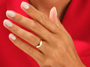 Gold wedding band on a hand with manicured nails, jewelry