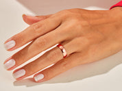 Rose gold band ring on a woman's finger, jewelry product photography