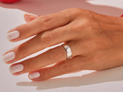 Silver band ring on a hand with manicured nails
