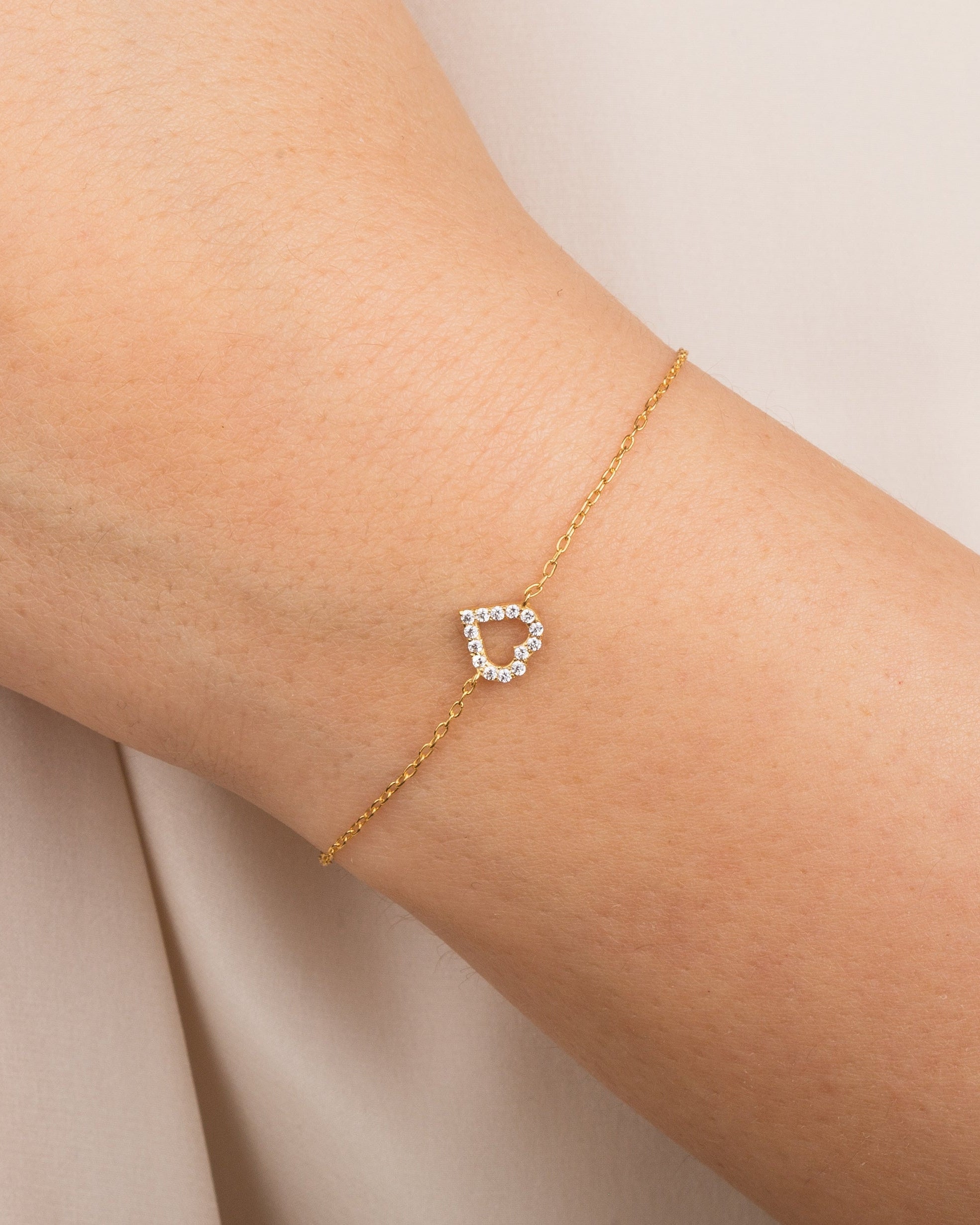Gold heart bracelet with diamonds on a woman's wrist