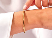 Gold geometric bangle on wrist, jewelry photography