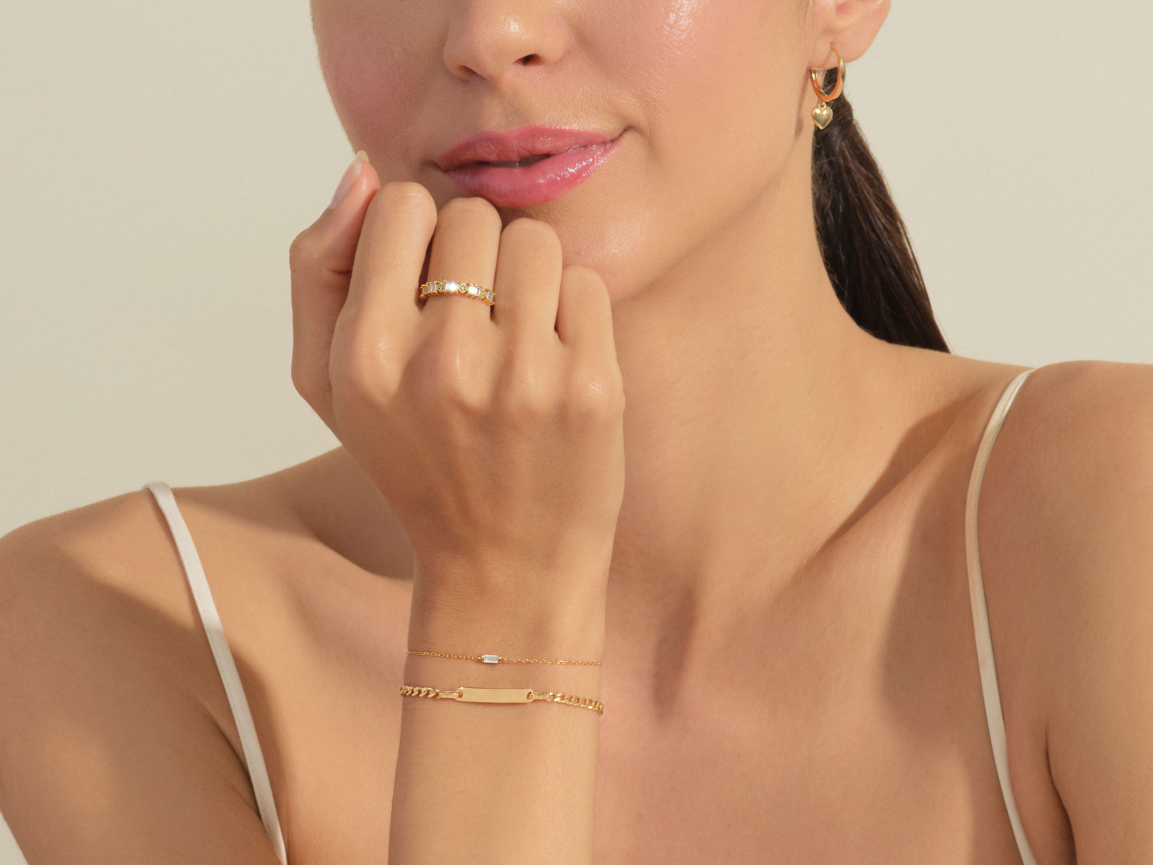 Gold jewelry on woman: ring, bracelet, heart earrings