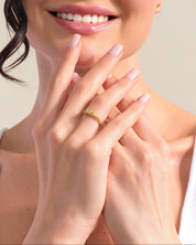 Woman wearing a gold diamond ring, showcasing fine jewelry
