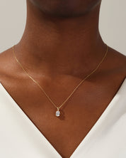 Gold oval diamond pendant necklace on a woman's neck
