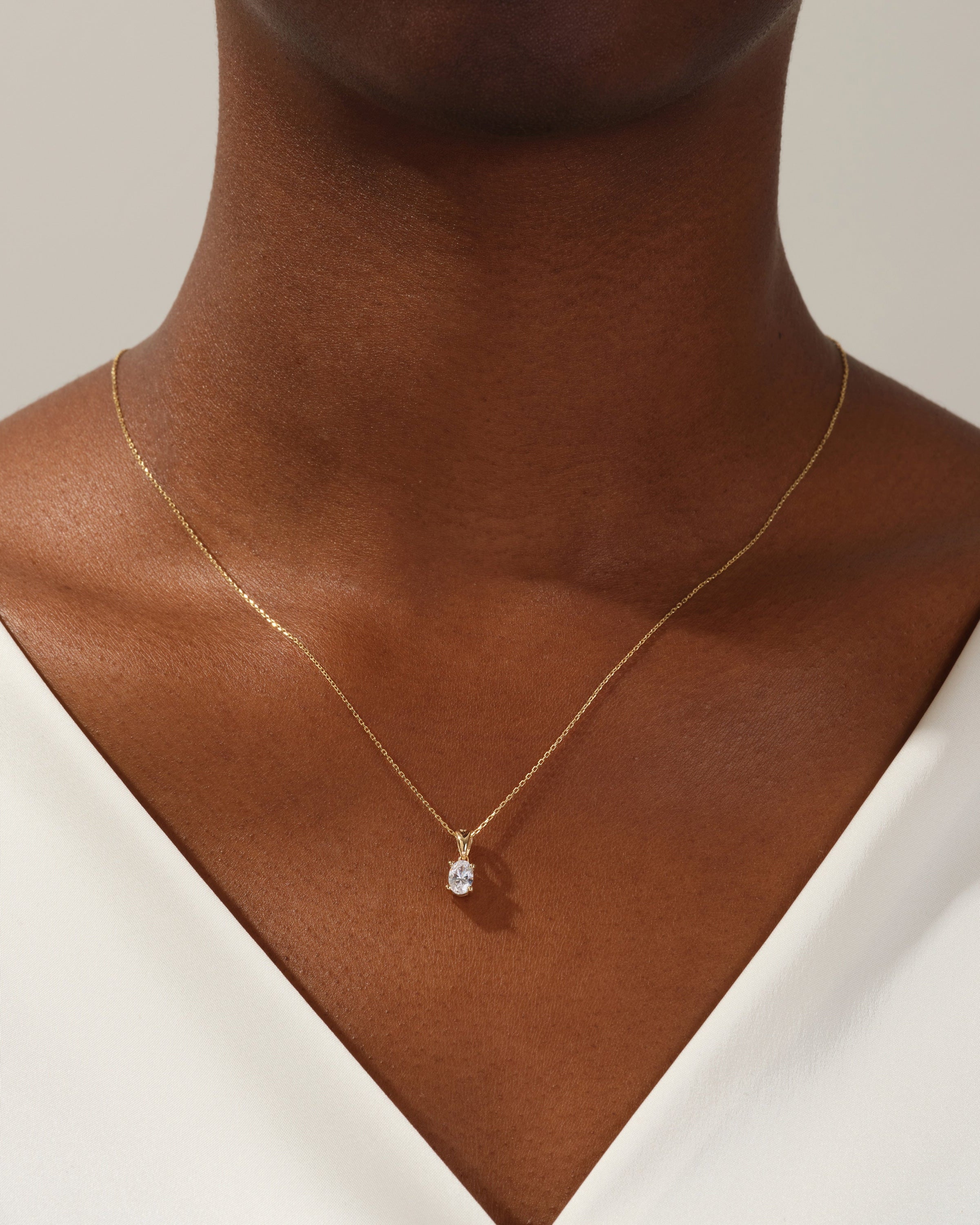 Gold diamond pendant necklace on a woman's neck