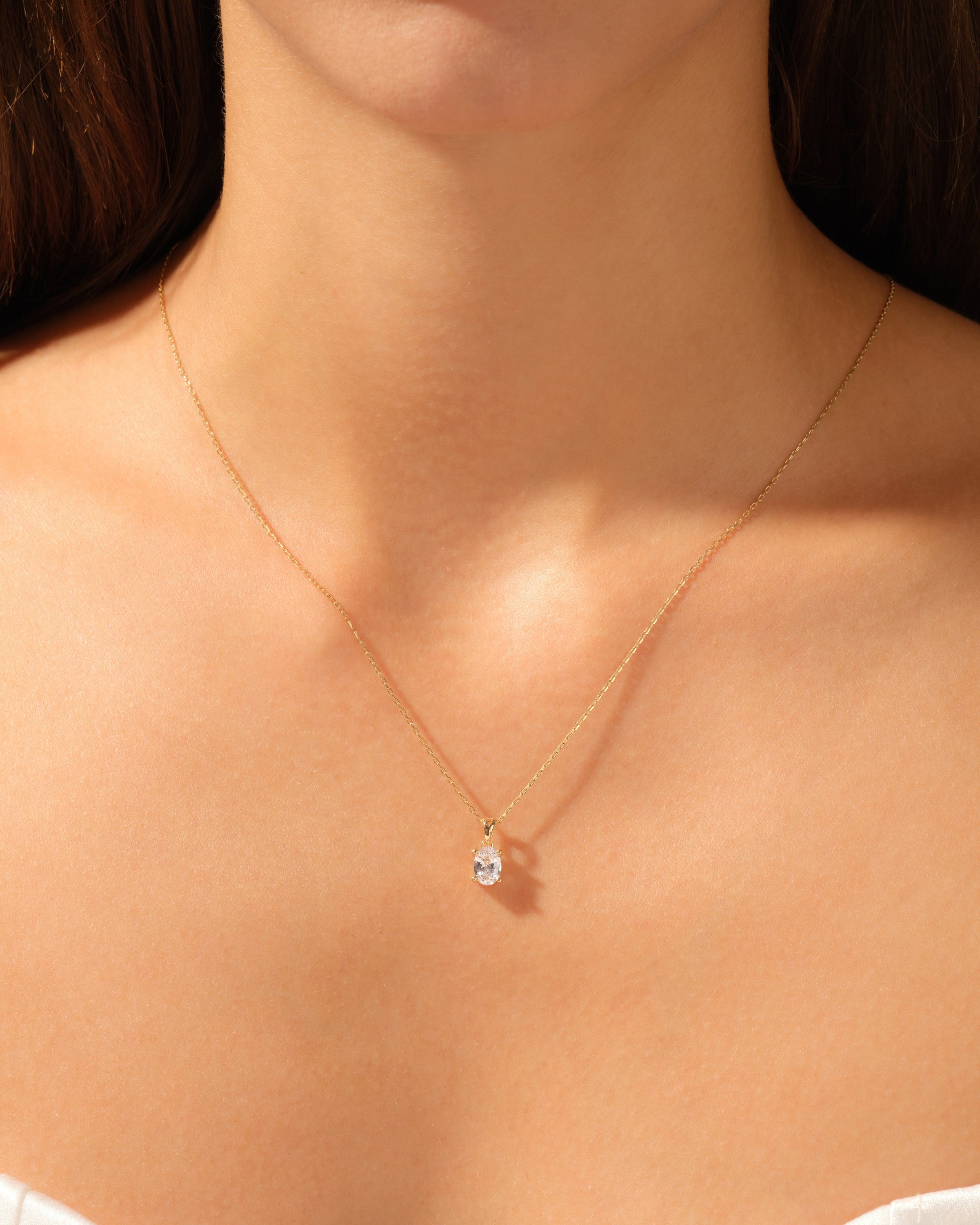 Gold necklace with diamond pendant on woman's neck