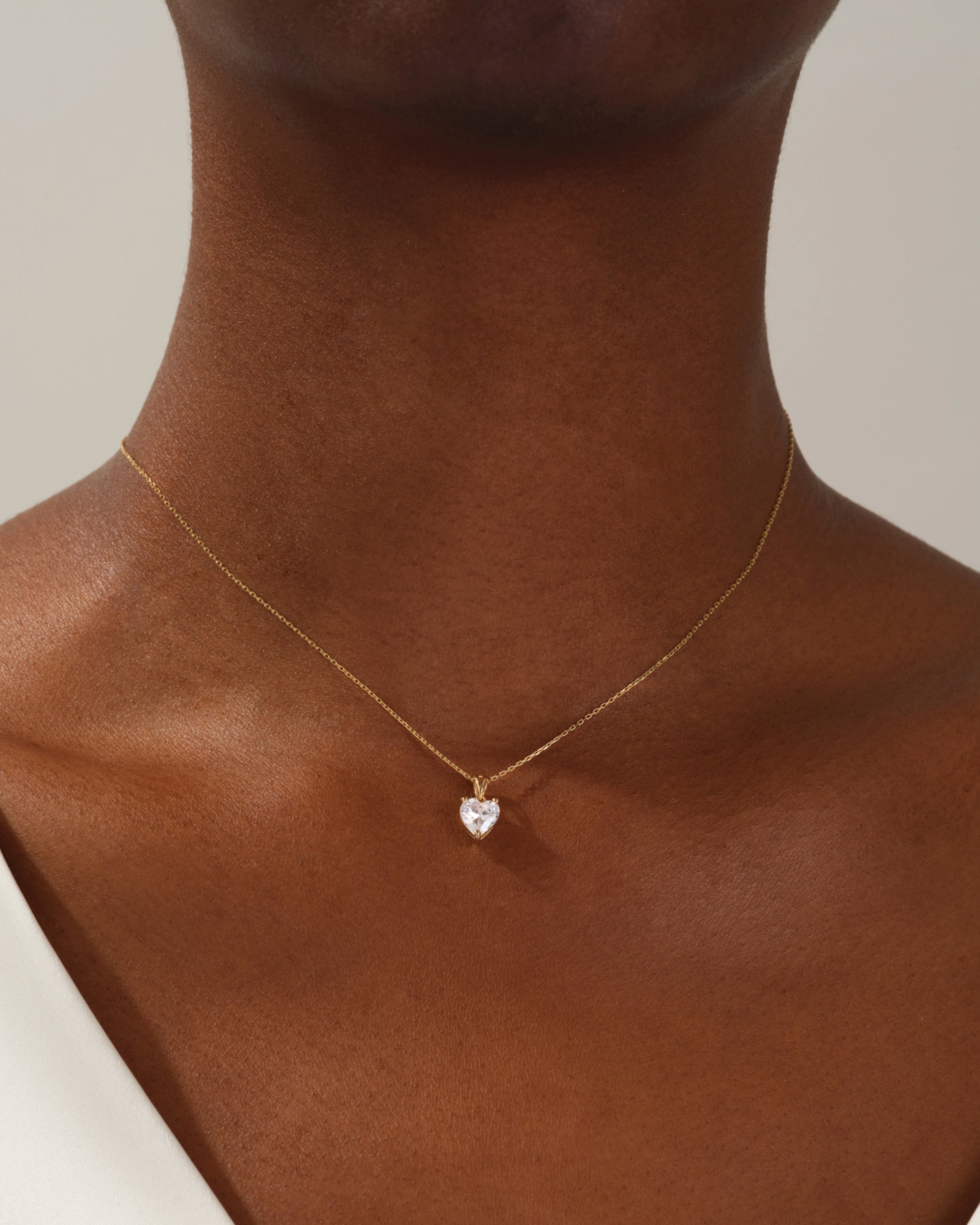 Gold heart necklace with diamond pendant on model