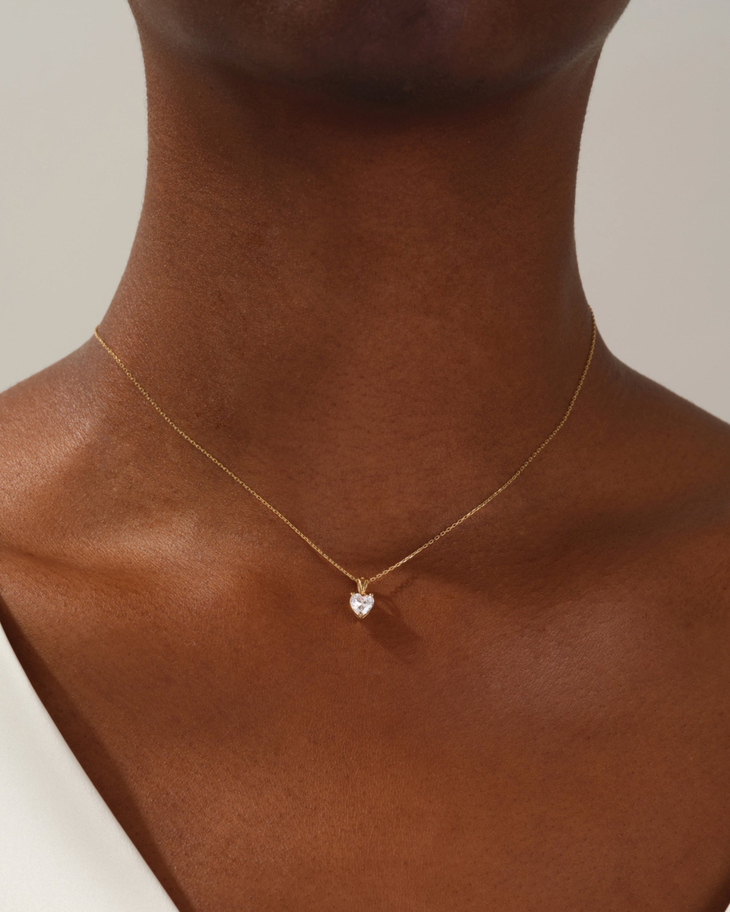 Gold heart necklace with diamond pendant on model