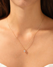 Gold heart necklace with diamond pendant on a woman's neck