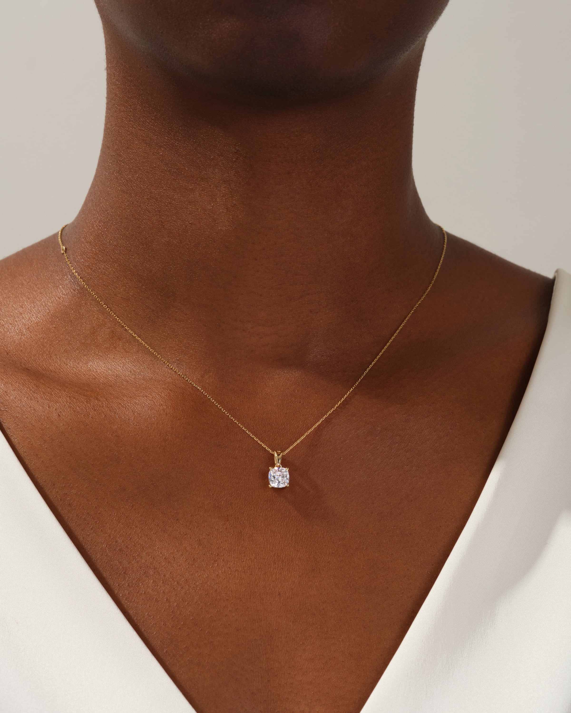 Gold necklace with diamond pendant on model