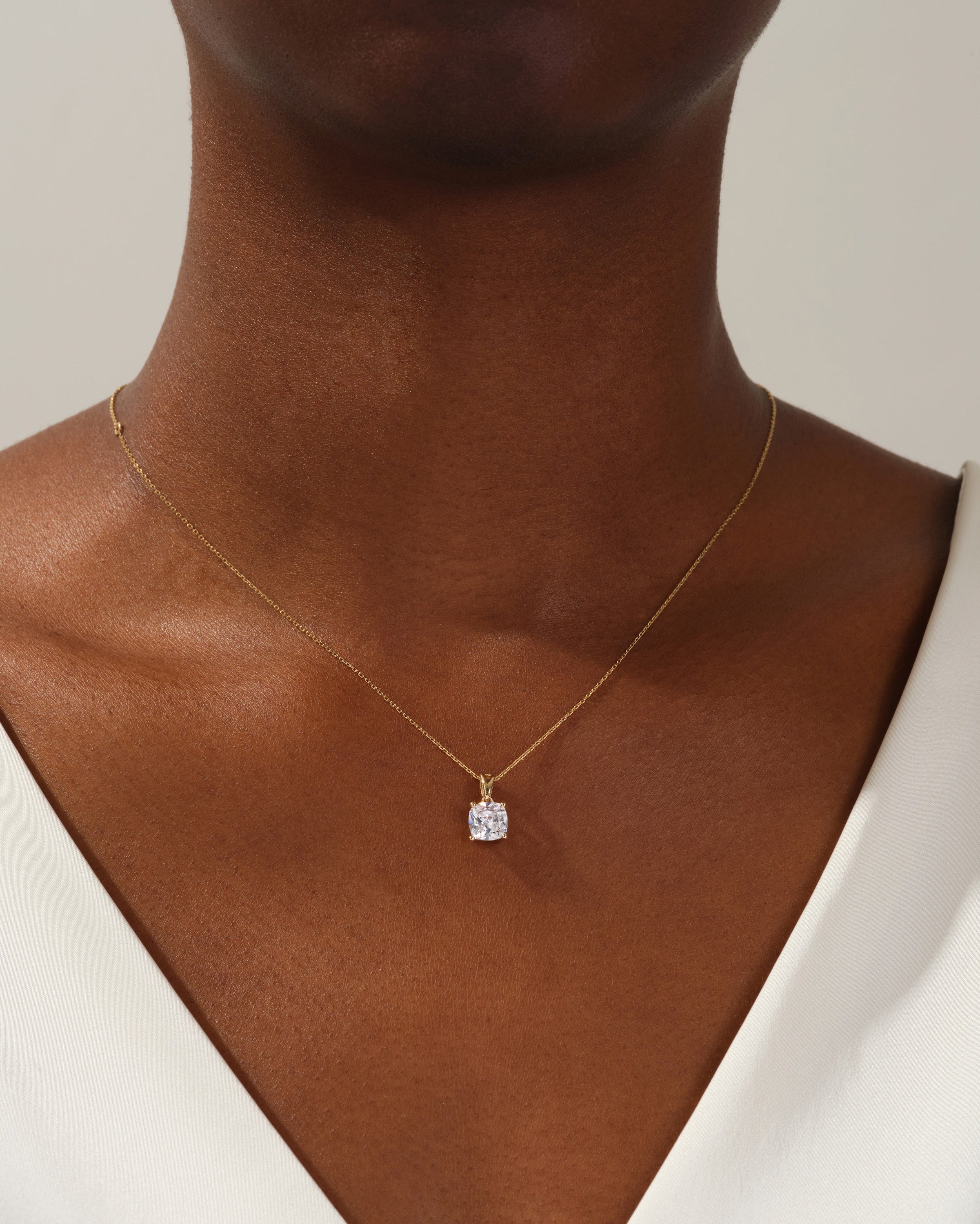 Gold necklace with diamond pendant on a woman's neck