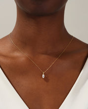 Gold necklace with marquise diamond pendant on woman's neck