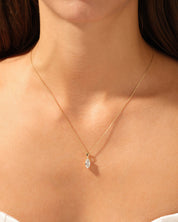 Gold necklace with diamond pendant on a woman's neck