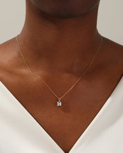 Gold necklace with diamond pendant on model
