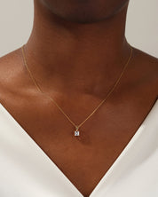 Gold necklace with diamond pendant on a woman's neck