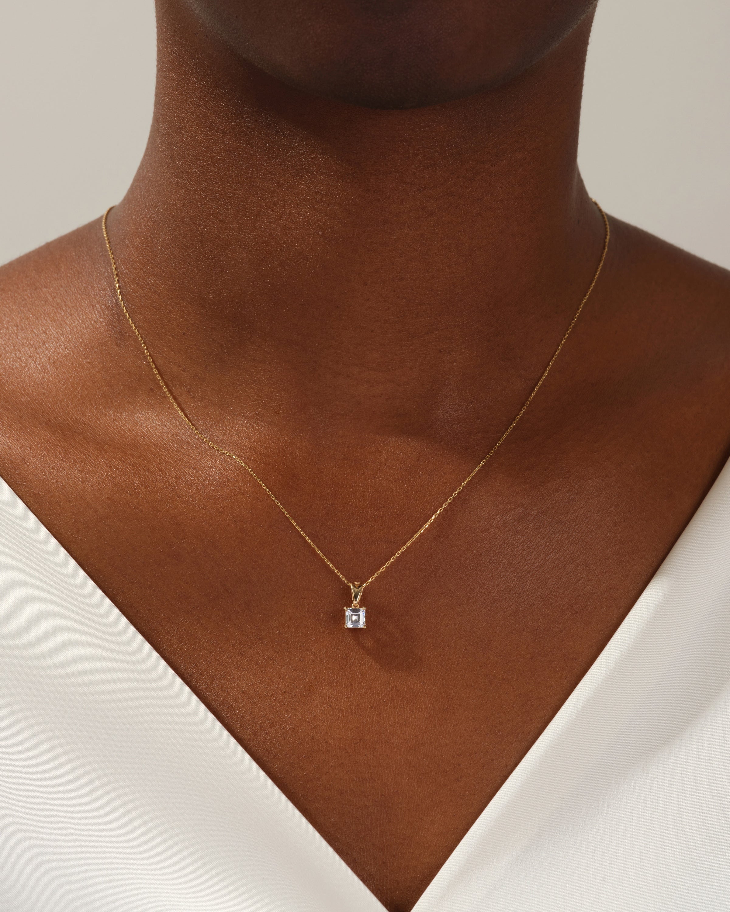 Gold necklace with diamond pendant on a woman's neck