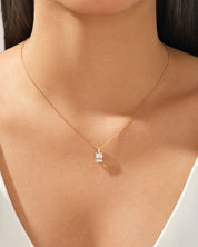 Gold necklace with a radiant diamond pendant on a woman's neck