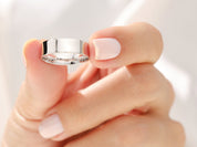 Elegant silver ring held by a manicured hand, jewelry product