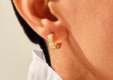 14k Gold, Yellow, White, Rose, Light 14k Yellow Gold Infinity Huggie Earrings in a womans ear